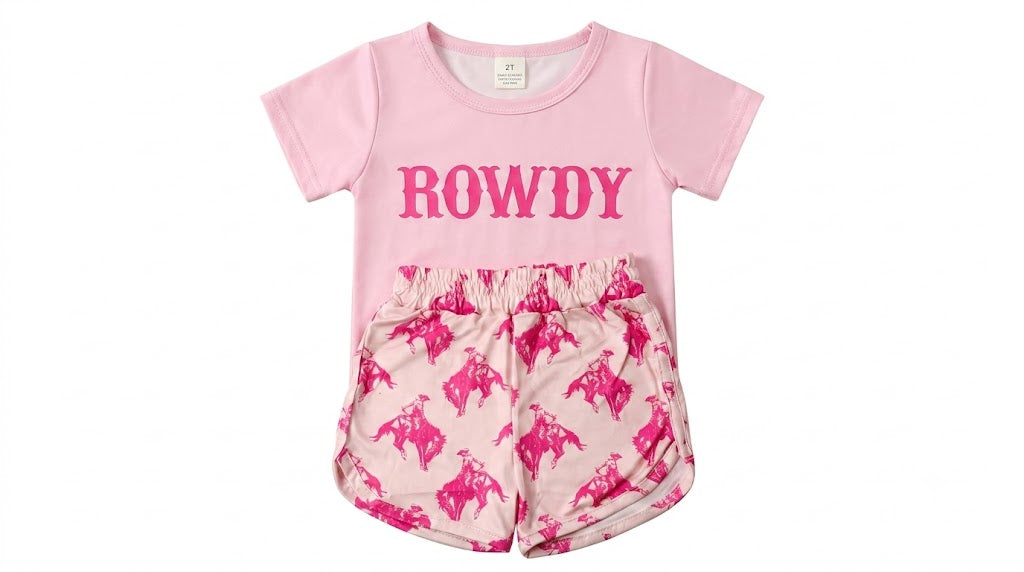 Girls 2-piece Sweet & Rowdy set featuring a light pink short-sleeve tee with bold pink ROWDY graphic lettering, paired with cream shorts with an all-over pink western bull rider print and elastic waistband